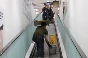 Nhân viên đặt thùng hứng axit nhỏ xuống từ trần trung tâm mua sắm Skyline Plaza tại quận Tsuen Wan ở Hồng Công (Trung Quốc) ngày 6-8-2017. Ảnh: SCMP