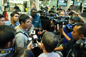 HLV Hữu Thắng (giữa) trả lời truyền thông Malaysia. Ảnh: Dũng Phương