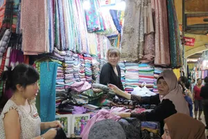 Khách hàng tìm mua khăn quàng cổ tại một sạp ở chợ Bến Thành ngày 26-10