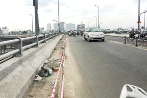 Phần lề đường dành cho người đi bộ trên cầu Nguyễn Tri Phương đang bị  phá bỏ để mở rộng lòng đường, người đi bộ không còn lối đi qua cầu   