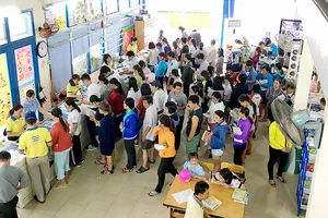 Xếp hàng chờ trả tiền mua sách giáo khoa tại nhà sách       Ảnh: CAO THĂNG