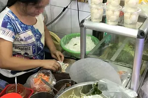 Người bán hàng dùng tay trần chế biến thức ăn cho khách Ảnh: HOÀNG HÙNG