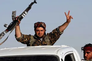 Một chiến binh SDF ăn mừng chiến thắng IS trên đường phố Raqqa. Ảnh: REUTERS