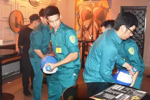 Đội tuần tra liên ngành quận 1, TPHCM và phường Phạm Ngũ Lão  lập biên bản tạm giữ các bình khí N2O tại một quán bar trên đường                Nguyễn Quang Đẩu vào khuya 29-9-2018.        Ảnh: QUANG HUY