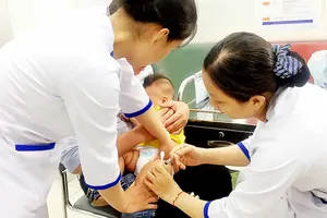 Phụ huynh đưa trẻ đi chích ngừa sởi tại một cơ sở tiêm chủng dịch vụ trên địa bàn TPHCM.   Ảnh: HOÀNG HÙNG