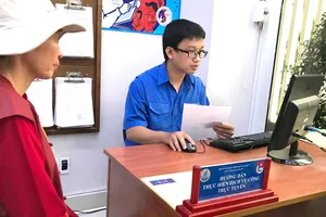 Công chức quận 4 tư vấn cho người dân nộp hồ sơ qua mạng.  Ảnh: VIỆT DŨNG