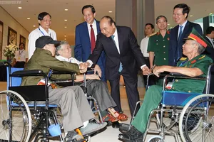 Thủ tướng thăm hỏi các đồng chí thương binh nặng tới dự buổi gặp mặt. Ảnh: VGP