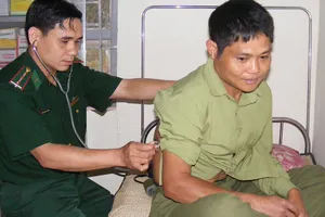 Thượng úy Trần Văn Cường khám bệnh cho người dân  bản Huồi Bắc (xã Bắc Lý, huyện Kỳ Sơn)