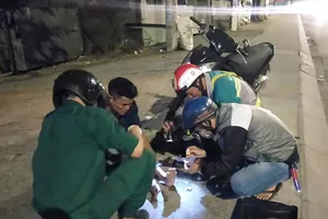 Các thành viên Đội cứu trợ giao thông quận 12 giúp đỡ người bị té xe dọc đường