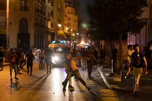 Người biểu tình ném đá về phía lực lượng an ninh tại Beirut. Ảnh: AP