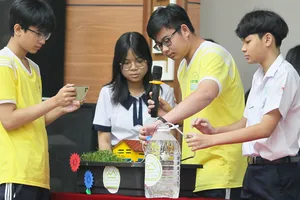 Các em giới thiệu hệ thống tưới tự động bằng cảm ứng đo độ ẩm  của đất.  Ảnh: HOÀNG HÙNG