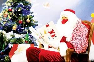 Một nhân viên bưu điện ở Libourne, Tây Nam nước Pháp  hóa trang thành ông già Noel đọc thư của các em bé