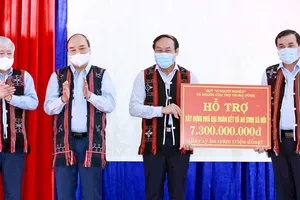 Chủ tịch nước Nguyễn Xuân Phúc chứng kiến lãnh đạo Ủy ban MTTQ Việt Nam trao số tiền xây dựng  nhà Đại đoàn kết và an sinh xã hội cho hai huyện Đông Giang và Tây Giang, tỉnh Quảng Nam. Ảnh: TTXVN