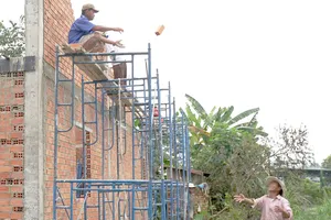 Công nhân xây nhà phổ thông tại huyện Củ Chi, TPHCM  thiếu an toàn trong lao động. Ảnh: HOÀNG HÙNG