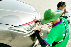 Nhiều tài xế phải dừng xe trên đường cao tốc để dán thẻ  thu phí tự động. Ảnh: HOÀNG BẮC