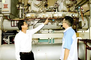 Anh Bùi Trọng Hữu trao đổi cùng công nhân trẻ  về sáng kiến anh đã thực hiện.  Ảnh: THÁI PHƯƠNG