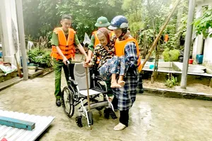 Lực lượng vũ trang tỉnh Quảng Nam hỗ trợ người già yếu đến nơi an toàn. Ảnh:  MINH HUY