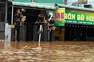 Cơn mưa lớn kéo dài tối ngày 27-7 làm nước dâng khiến người dân leo lên cao chờ lực lượng chức năng đến hỗ trợ