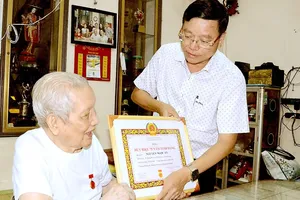 Bí thư Quận ủy quận Bình Thạnh Vũ Ngọc Tuất trao Huy hiệu 75 năm tuổi Đảng tới đồng chí Nguyễn Ngọc Ẩn, năm 2022. Ảnh: HOÀNG ANH