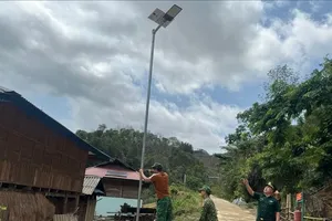 Các chiến sĩ Đồn Biên phòng Pa Thơm lắp đặt cột đèn cao áp cho dân bản