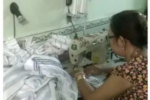 Người may gia công miệt mài làm việc để mong trang trải  cho cuộc sống gia đình
