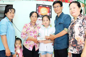 Đại diện Báo SGGP trao 25,5 triệu đồng do bạn đọc báo ủng hộ gia đình cháu Lê Thị Bảo Linh. Ảnh: NGỌC OAI