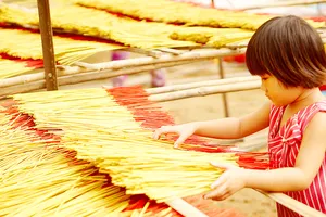 Một cô bé 9 tuổi đã biết phụ giúp gia đình phơi nhang tại làng nhang Lê Minh Xuân