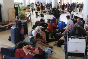 Các du khách nước ngoài ngồi, nằm la liệt ở sân bay quốc tế Lambok sau trận động đất ngày 6-8. Ảnh: REUTERS