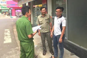Ông Nguyễn Văn Ba (giữa) cùng Công an phường Xuân An tuyên truyền phòng chống tội phạm cho một cơ sở kinh doanh trên địa bàn