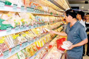 Khách hàng chọn mua các loại thịt gia cầm bình ổn tại cửa hàng San Hà Foodstore. Ảnh: TƯỜNG DÂN