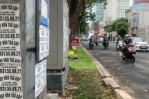 Quảng cáo dán đầy trên cột điện, tạo hình ảnh phản cảm  và nhếch nhác. Ảnh: DŨNG PHƯƠNG