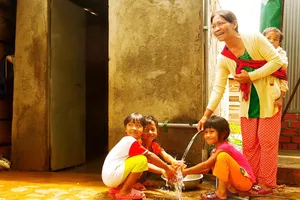 Bà H’Nhêr (dân tộc M’Rông) và con cháu bên dòng nước sạch  được kéo về tận nhà