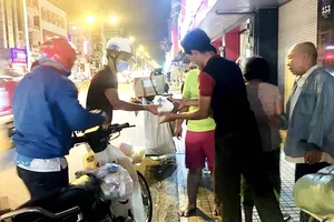 Các tình nguyện viên phân phát cháo cho người lao động  và người vô gia cư 