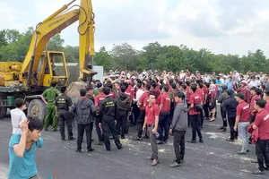 Nhân viên Công ty Alibaba cản trở lực lượng cưỡng chế sai phạm ở xã Tóc Tiên. Ảnh: NÔNG NGÂN