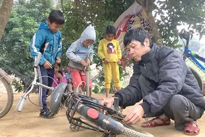 Anh Dũng sửa xe đạp cho các em học sinh ở bản Cồn