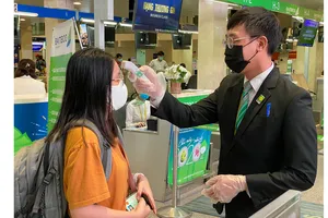 Kiểm tra thân nhiệt hành khách trước khi vào làm thủ tục lên máy bay tại sân bay Tân Sơn Nhất. Ảnh: CAO THĂNG