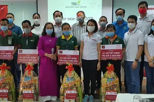 Bà Trần Thị Quỳnh Châu - Phó Giám đốc Agribank Bình Dương (thứ tư hàng đầu từ bên phải) tặng quà và sổ tiết kiệm cho công nhân có hoàn cảnh đặc biệt khó khăn của công ty TBS group