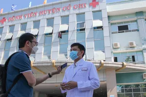 Phóng viên Báo SGGP tác nghiệp ở Bệnh viện Huyện Củ Chi.  Ảnh: DŨNG PHƯƠNG