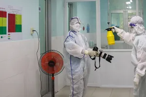 Phóng viên  Báo SGGP thực hiện nghiêm túc và đầy đủ việc khử trùng để vào Bệnh viện Huyện Củ Chi tác nghiệp. Ảnh: DŨNG PHƯƠNG