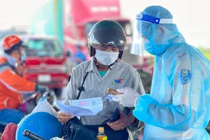 Kiểm tra giấy thông hành vào thành phố tại trạm Ngã 3 Làng - QL1A- Bình Chánh. Ảnh: HOÀNG HÙNG
