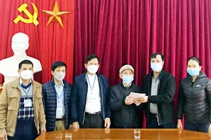 Cụ Đàm Điệt trao sổ tiết kiệm 100 triệu đồng  ủng hộ quỹ phòng chống dịch COVID-19  xã Hưng Thông (Nghệ An). Ảnh: TTXVN