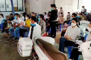 Người dân ngồi chờ làm thủ tục tại UBND xã Vĩnh Lộc A, huyện Bình Chánh, TPHCM