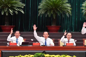 Các đồng chí lãnh đạo TPHCM biểu quyết thông qua nghị quyết hội nghị. Ảnh: VIỆT DŨNG