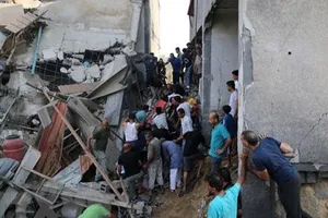 Người dân tìm kiếm người bị mắc kẹt trong những đống đổ nát sau vụ không kích của Israel tại Khan Younis, Dải Gaza, ngày 11-10-2023