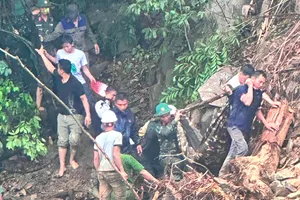 Lực lượng chức năng đưa các nạn nhân từ trên hiện trường sạt lở xuống 