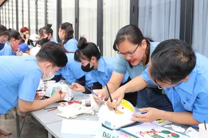 Công nhân Công ty CP Hợp tác Kinh tế và Xuất nhập khẩu Savimex tham gia cuộc thi “Vẽ, trang trí nón bảo hiểm” ngay sân nhà máy