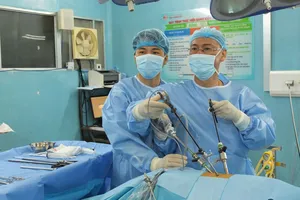 Ê kíp phẫu thuật Bệnh viện Bình Dân sử dụng robot phẫu thuậtcắt bướu bảo tồn thận. Ảnh: MINH KHUÊ