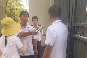 Hình ảnh bà Nguyễn Thị Út Em (người đội mũ màu vàng) cùng một số người đến trước cổng trường vào chiều 26-3