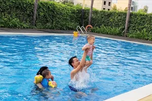 Cùng con trẻ đi bơi, tạo niềm vui sau giờ làm. Ảnh: THANH HƯƠNG