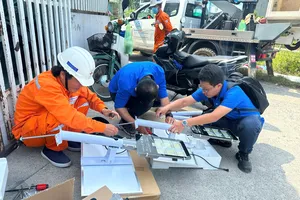 Anh Nguyễn Hoàng Thắng (bên phải) cùng đồng nghiệp thực hiện công trình thanh niên lắp đặt đèn năng lượng mặt trời cho các tuyến hẻm